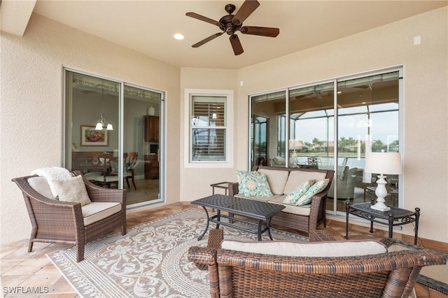 sunroom / solarium with ceiling fan with notable chandelier