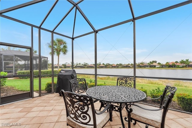 sunroom featuring a water view