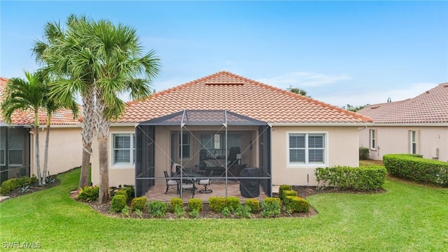 back of house with a lanai, a lawn, and a patio