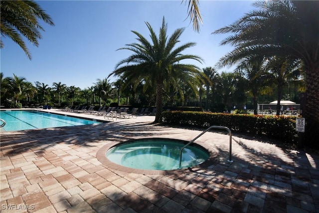 view of swimming pool featuring a patio and a community hot tub