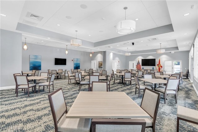 dining space featuring a raised ceiling and carpet floors