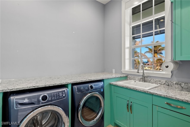 clothes washing area with cabinets, independent washer and dryer, and sink