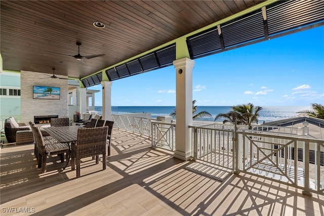 exterior space with ceiling fan, a beach view, and a water view