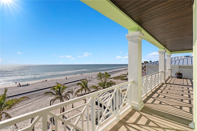 balcony featuring a view of the beach and a water view