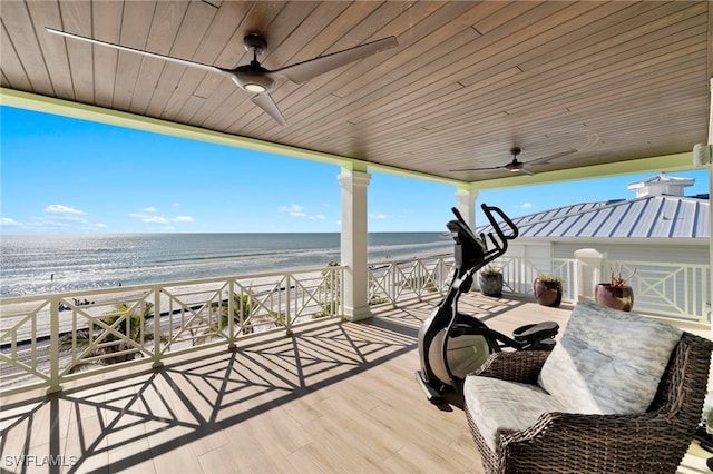 exterior space featuring a water view, ceiling fan, and a view of the beach