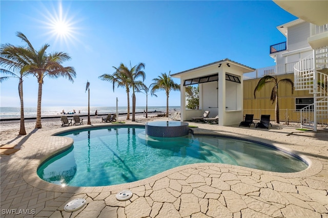 view of swimming pool featuring a water view and a patio