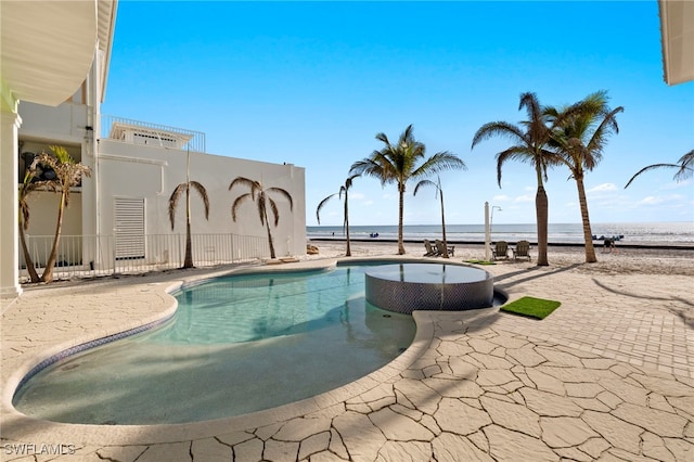 view of swimming pool featuring a patio and a water view