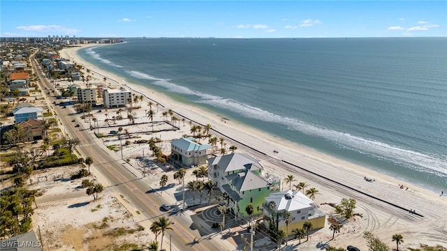 birds eye view of property with a water view and a beach view