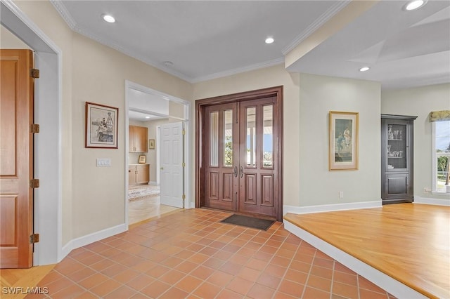 tiled foyer with plenty of natural light and crown molding