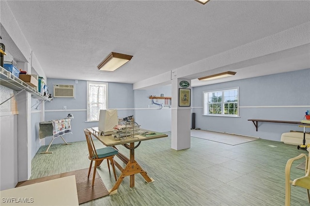 interior space with a wall mounted AC, wood-type flooring, and a textured ceiling