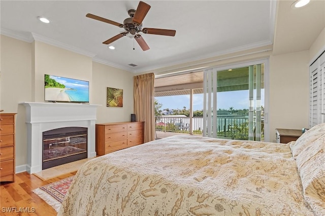 bedroom featuring ceiling fan, light hardwood / wood-style floors, ornamental molding, and access to outside