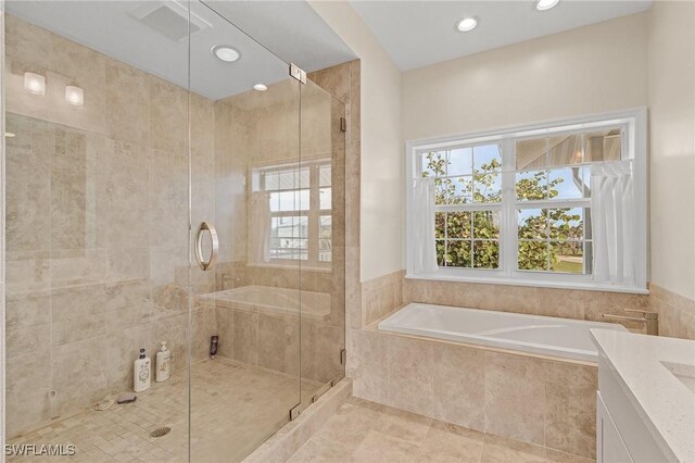 bathroom with vanity, tile patterned flooring, and plus walk in shower