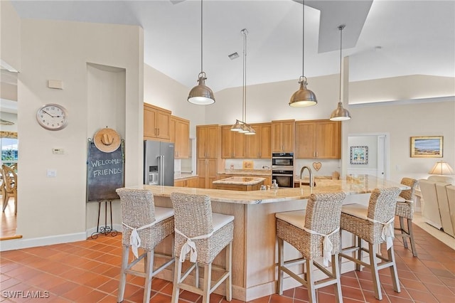 kitchen featuring hanging light fixtures, a kitchen breakfast bar, high vaulted ceiling, high quality fridge, and light tile patterned flooring