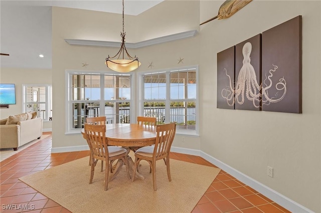 dining space with a towering ceiling and tile patterned floors