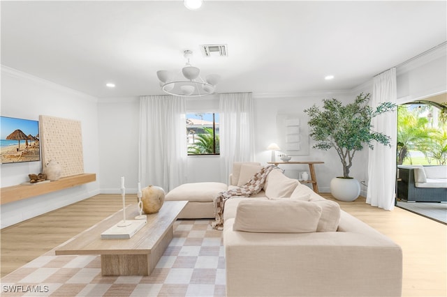 living room featuring crown molding, light hardwood / wood-style flooring, and a chandelier