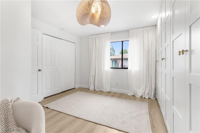 bedroom with light hardwood / wood-style floors and a closet