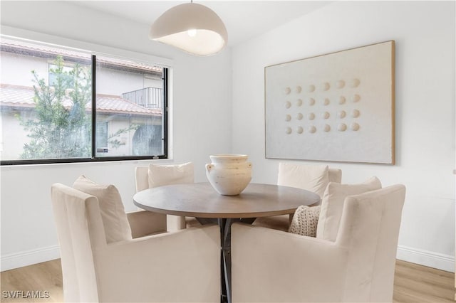 dining area with light wood-type flooring and a healthy amount of sunlight