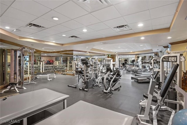 exercise room featuring a raised ceiling and a paneled ceiling