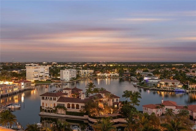 aerial view at dusk featuring a water view