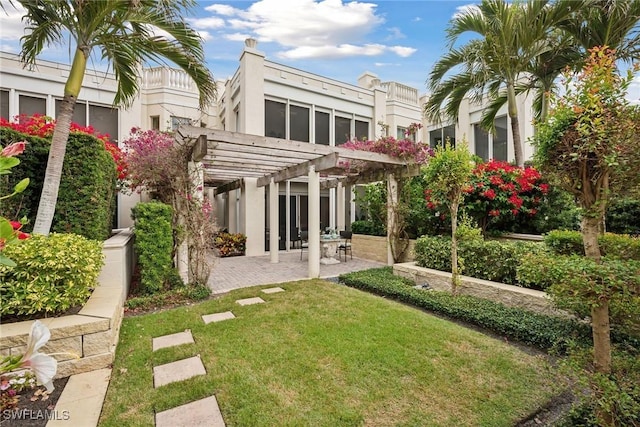 back of property with a patio, a yard, and a pergola