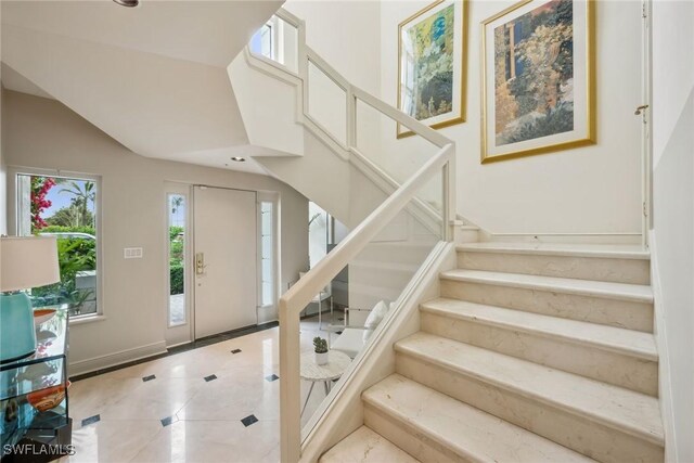 stairway featuring tile patterned flooring and a towering ceiling