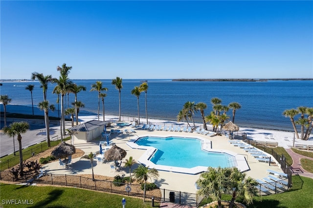 view of swimming pool with a patio area and a water view