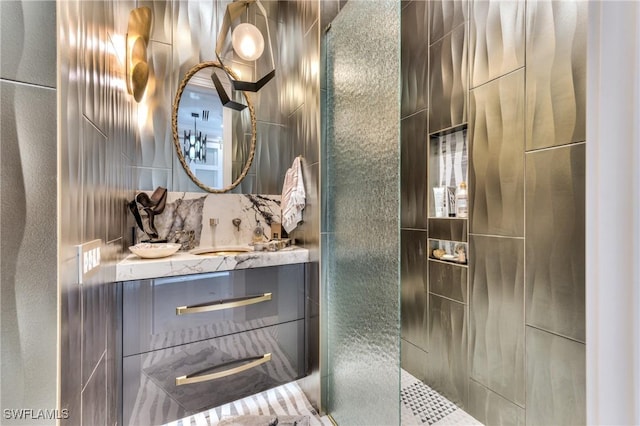 bathroom with tiled shower and vanity