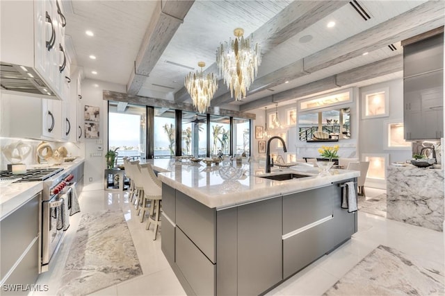 kitchen featuring gray cabinets, sink, white cabinetry, a kitchen island with sink, and high end stainless steel range