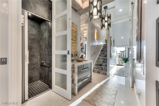 bathroom with tiled shower and tile patterned flooring