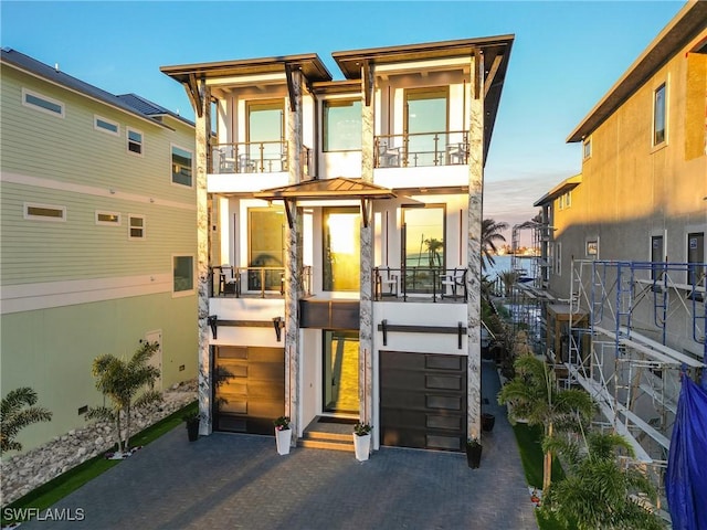 view of front of property featuring a balcony and a garage