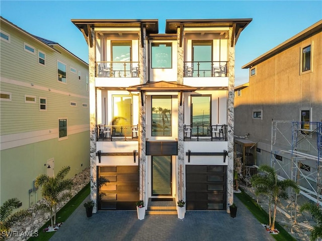 view of front of property featuring a balcony and a garage