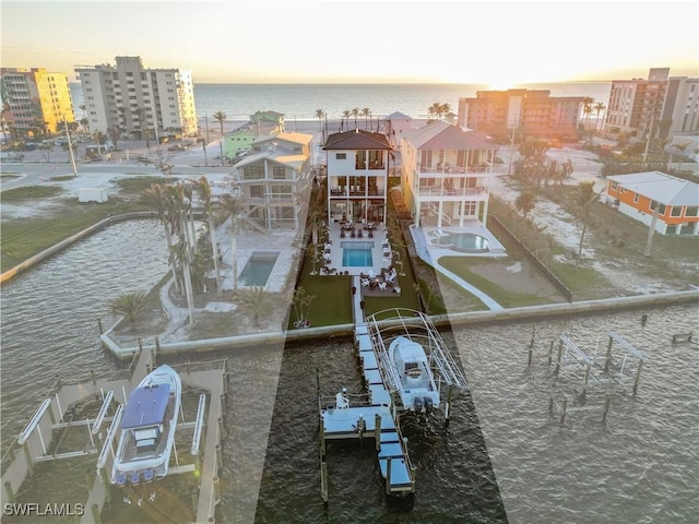 aerial view at dusk featuring a water view