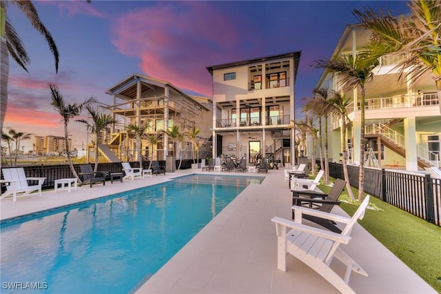 community pool with a patio area and fence