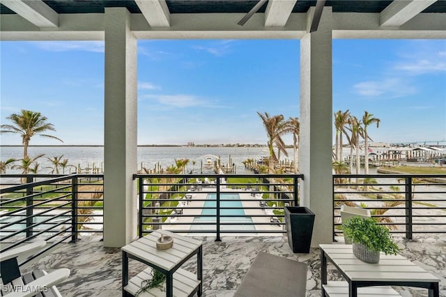 view of patio with a balcony, a ceiling fan, and a water view