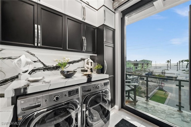 clothes washing area featuring cabinet space and washing machine and dryer