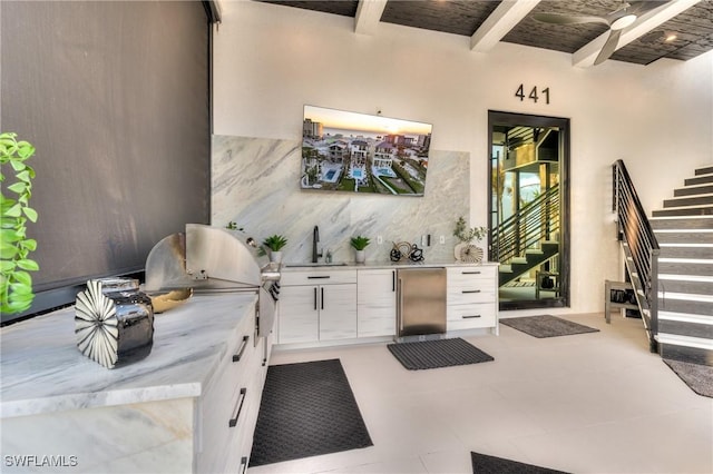 interior space with an outdoor kitchen, a sink, and stairs