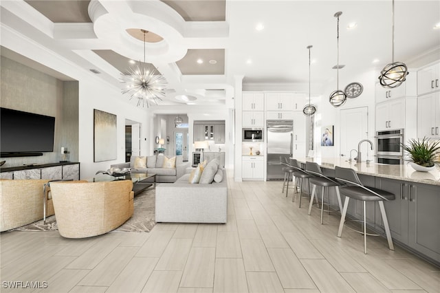 living room with coffered ceiling, crown molding, beam ceiling, a chandelier, and a high ceiling