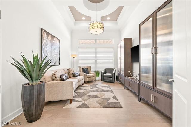 living room with light hardwood / wood-style flooring, a high ceiling, and ornamental molding