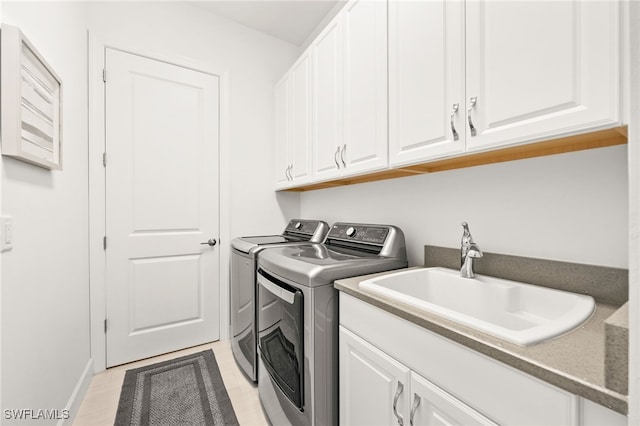 laundry room with cabinets, independent washer and dryer, and sink