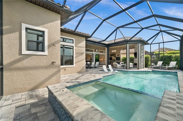 view of pool with glass enclosure, ceiling fan, and a patio