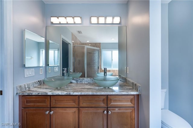 bathroom featuring walk in shower, vanity, and toilet