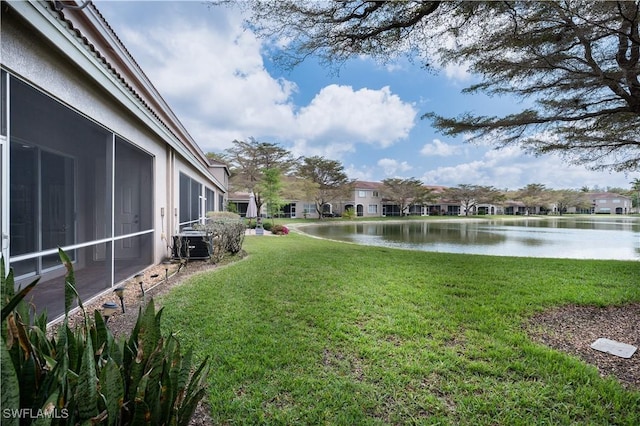 view of yard with a water view and central AC