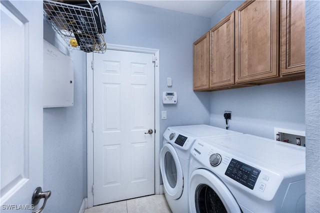 clothes washing area with cabinets, light tile patterned floors, and separate washer and dryer