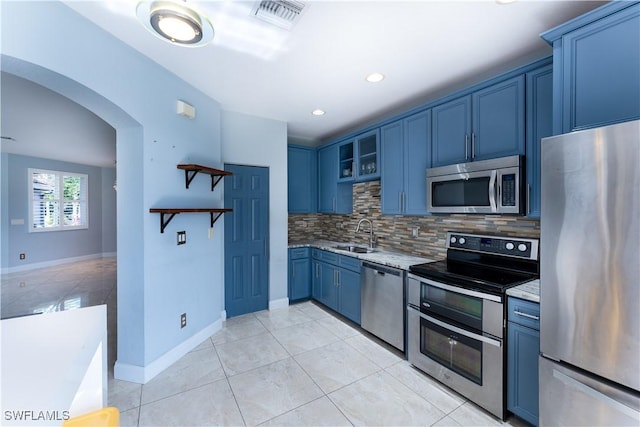 kitchen with decorative backsplash, blue cabinetry, sink, and stainless steel appliances