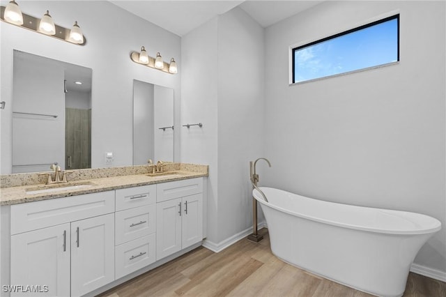 bathroom with hardwood / wood-style floors, vanity, and separate shower and tub