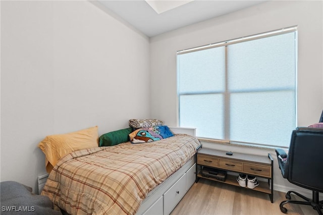 bedroom with light wood-type flooring and multiple windows