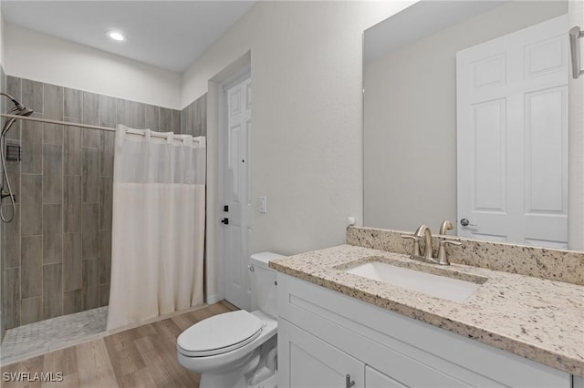 bathroom with vanity, hardwood / wood-style flooring, toilet, and walk in shower