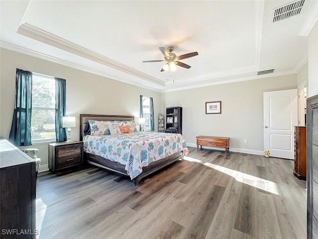 bedroom with a tray ceiling, ceiling fan, and hardwood / wood-style flooring