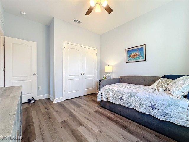 bedroom with ceiling fan, a closet, and light wood-type flooring