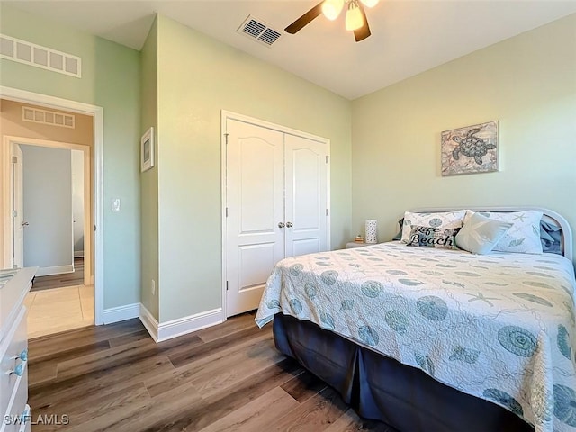 bedroom featuring ceiling fan, wood-type flooring, and a closet